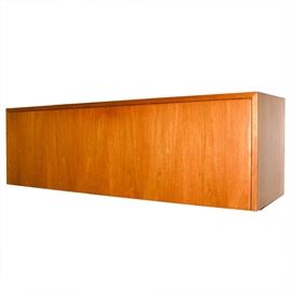 Otmar Mid-Century Floating Wall Storage Cabinet: A mid-century floating wall cabinet made by Otmar. This sleek cabinet is constructed of wood with a hinged drop-front door with center push-closure. The inner cabinet is divided to the center.