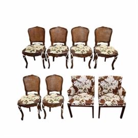 Wooden Floral Motif Chairs: A set of chairs. This selection includes eight pieces, two of which are armchairs and six without arms.The chairs feature foliate upholstery in shades of brown, green, and white.