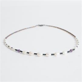 Vintage Sterling Silver and Mother of Pearl Beaded Necklace: A vintage sterling silver and mother of pearl beaded necklace. This necklace features a sterling silver springring clasp with graduated mother of pearl and blue and purple, possibly glass, beads. It is marked twice with “925” and “sterling” on the clasp and weighs 0.18 ozt.