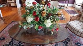 Oval flame mahogany inlaid coffee table with floral arrangement