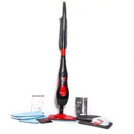 Haan Steam Cleaner: A Haan steam cleaner. The haan steam cleaner is black in color with red accents, a clear water tank, and a black power cord. Included with the steamer are four refill pads, a package of “fresh rinse”, and the original instruction manual.