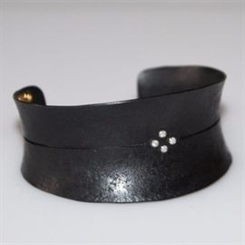 Starlight Cuff Bracelet by Pat Flynn: A statement cuff bracelet by designer Pat Flynn. The open cuff bracelet is forged from black iron, and features a distressed finish. It is punctuated with a group of four petite tightly spaced diamonds.