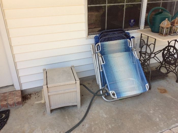 Outside patio - hose reel, lawn chairs, singer sewing machine frame with marble top