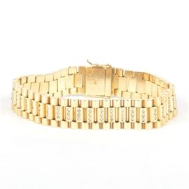 18K Yellow Gold Link and Diamond Bracelet: An 18K yellow gold bracelet accented by small diamonds on the center links.