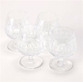 Waterford Crystal Stemware: A set of Waterford crystal stemware. The short-stemmed snifters feature a tight diamond pattern at the bottom of the bowl and vertical thumbprints rising toward the uncut rim.The four pieces are marked to the clear foot “Waterford”.