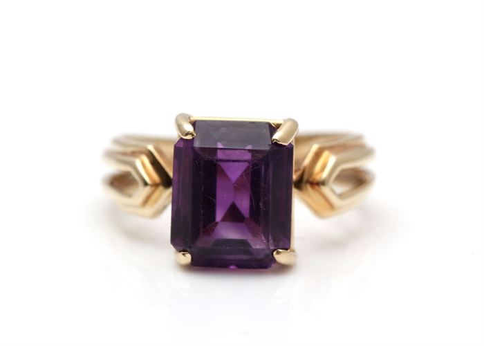 14K Yellow Gold Amethyst Ring: A faceted dark purple amethyst is basket prong set to a split yellow gold shank.