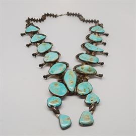 Vintage Native American 800 Silver Turquoise Squash Blossom Necklace: A vintage Native American 800 silver turquoise squash blossom necklace. This heavy necklace features a double strand of handmade etched seed beads with turquoise stones designed with squash blossoms and leaf detailing.