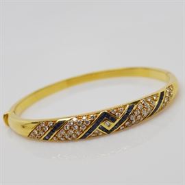 Fred Joaillier 18K Yellow Gold Diamond and Sapphire Bracelet: A French 18K yellow gold diamond and sapphire bracelet by FRED Joaillier. This bracelet features channel set sapphires and bead and bright set diamonds, on a curved link chain, with a hinge and hidden box tab. FRED Paris Joaillier is known for jewelry made specifically for many films and celebrities.