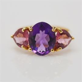 14K Yellow Gold Amethyst and Pink Tourmaline Ring: A 14K yellow gold amethyst and pink tourmaline ring. Ring features a basket set center oval amethyst and two side heart-shaped pink tourmaline.
