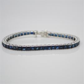 Vintage Platinum Sapphire Link Tennis Bracelet: A vintage platinum sapphire tennis bracelet. Each link features a bar set square faceted sapphire, secured with a platinum box clasp.