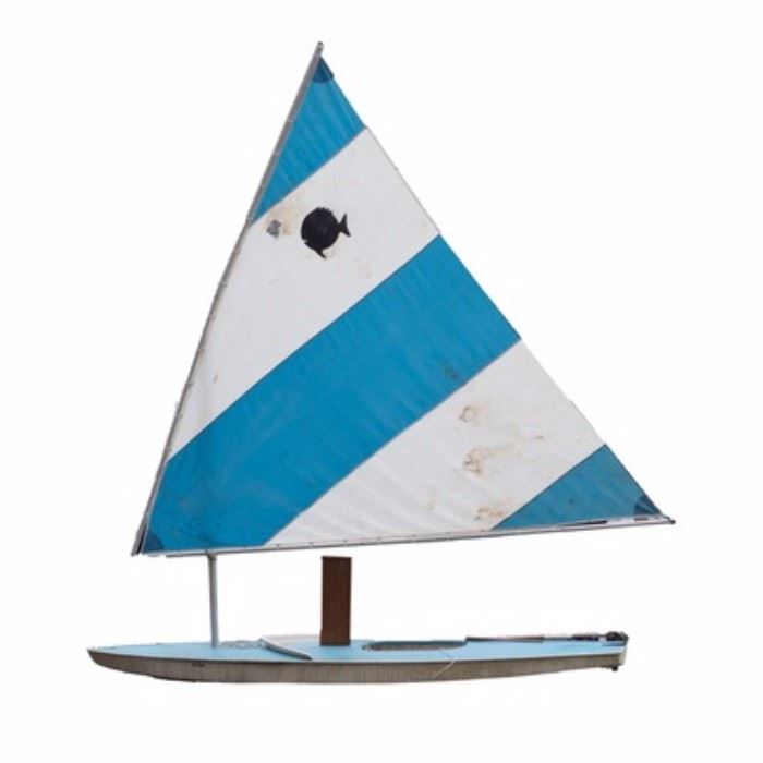 Alcort Sunfish Sailboat: An Alcort Sunfish sailboat. Included is a personal-sized sailboat with a fiberglass boat frame and down-wind sail. The Sunfish was originally introduced by Alcort in 1952. This boat has a blue coloring with an alternating stripe pattern along the sail of blue and white.
