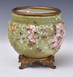Wave Crest Jardiniere	
scroll molded with pink flowers on a 
green ground, the gilt metal base with cherubs
8" high
early 20th century