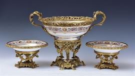 Sevres Console Three Piece Set	
Chateau de Fontainebleau pattern
with game scene decoration
the center piece, 13" high and 
18" diameter including the handles
the matching side compotes, 10 3/4" diameter
19th century