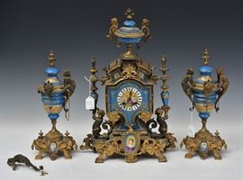 Sevres Style Three Piece Clock Set
painted porcelain with gilt mounts, 
the clock , 19 1/2" high and the 
two garnitures,13 3/4" high
late 19th century