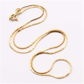 18K Yellow Gold Chain Necklace: A 18K yellow gold chain necklace. This necklace features a cobra chain connected to a spring ring clasp.