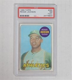 PSA Graded 1969 Reggie Jackson Rookie Card #260: A PSA graded 1969 TOPPS Reggie Jackson #260 rookie card. The card is encased, and has been graded by Professional Sports Authenticator (PSA), graded NM, 7 (OC).