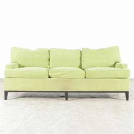 Chartreuse Color Upholstered Sofa: An upholstered sofa in a soft canvas chartreuse color. There are three back and three seat cushions, all removable. The sofa sits on black tapered wood legs.