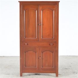 Vintage Pie Safe in Cherry: A cherry pie safe with two upper cabinet doors and pierced tin panels on the side. The top doors are solid and open to two removable shelves. Below is a full length drawer with two round knobs with machine cut dove tail construction. The lower cabinet has two doors and one knob, with one shelf inside. The piece stands on four straight legs.