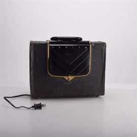 Vintage Zenith AM Radio: A vintage Zenith AM radio, circa 1950s. The model is G503 / Chassis 5G41. The radio is in a black hardshell case with with flip front that reveals raised logo that reads ‘The Royalty of Radio’ and with dials for station and speaker. The power cord tucks inside at the bottom. Follow the link for more details on this particular radio.