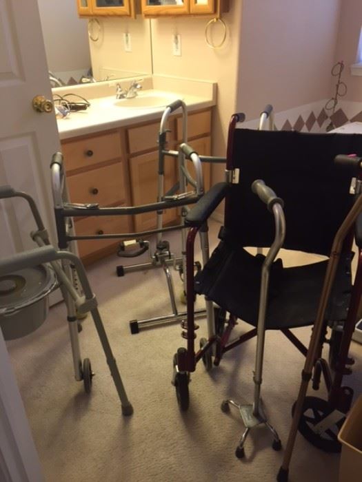 Various elderly medical equipment including canes, quad canes, wheelchair, bathroom chair, shower chair, 2 curling irons, small foot pedal therapy bike, walker