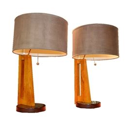 Pacific Coast Lighting Contemporary Table Lamps: A pair of Pacific Coast Lighting contemporary table lamps. Featuring grey canvas drum shades, this selection of two contemporary table lamps include single sockets, pull chains, geometric wooden columns and round wooden bases. They are marked to the undersides “2007 Pacific Coast Lighting, made in China.”
