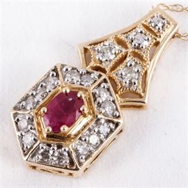 14K Yellow Gold, Ruby, and Diamond Drop Pendant Necklace: A 14K yellow gold drop pendant necklace. The pendant features one center faceted oval ruby framed by a halo of diamonds mounted in 14K white gold prong settings against a hexagonal frame with mil grain edges at the top.