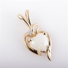 14K Yellow Gold, Diamond, and Heart Shaped Opal Pendant: A 14K yellow gold pendant featuring one center opal heart shaped cabochon accented at the top by one round brilliant cut diamond and a split bail.