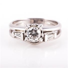 14K White Gold and Diamond Bridal Set: A 14K white gold and diamond soldered bridal set featuring one center round brilliant cut diamond mounted in an openwork prong setting flanked by baguette diamond side stones.