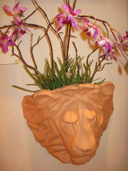 Terra cotta lions head planter with silk flowers. 