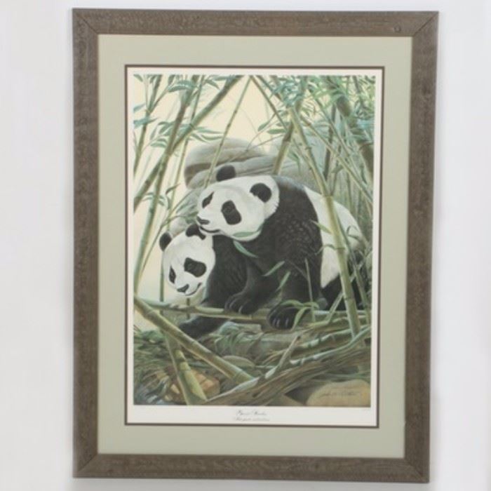 John Ruthven Limited Edition Offset Lithograph "Giant Pandas": A limited edition offset lithograph after John Ruthven’s Giant Pandas. This print depicts two pandas enclosed in a bamboo forest, one of which is standing on its paws eating a branch. An in plate and graphite signature are seen to the lower right corner of the composition, which is accompanied by a proof edition (2283/5000) and printed title to the margins. The print is presented under acrylic glass beneath double matting in a dark, natural wooden frame. To the verso is hanging wire, affixed sticker with print information, and a sepia tone composition of the print containing printed information on it tucked in the paper backing.