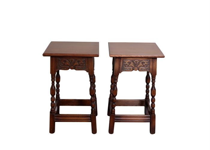 Pair of Antique Wooden Nightstands: A pair of antique wooden nightstands. This pair of wooden nightstands have spindle legs and square surfaces. Each side has decorative carvings in the wood. They have a front drawer that pulls out for storage.