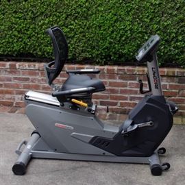 LifeCORE Exercise Bike: A LifeCORE exercise bike. This exercise bike is made by LifeCORE. It is a part of the 1050 ABs collection. The bike monitors calories burned, time, speed, heart rate, distance, and work out level. It is model LC-1050RBS. The serial number is 012043-035.