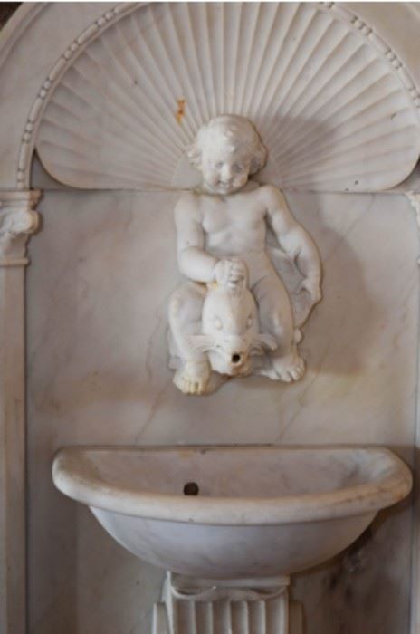 19thc, Italy, Carved marble wall fountain with putti  riding  a  dolphin, 75”h  x  33”w  x  10”d
