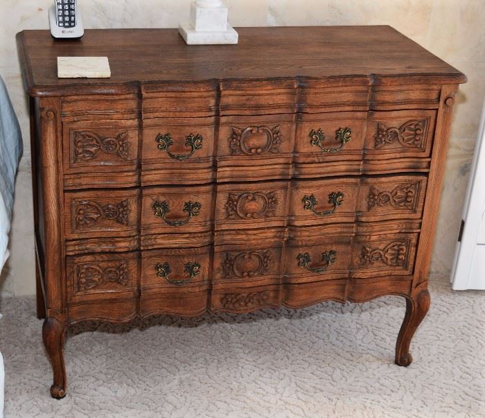 c.  1920,  Belgium.  Oak  ‘ribbon  front’  dresser  with  one  center  door  flanked  by  four  drawers  to  either  side,  carved  details  throughtout  and  bronze  handles,  36”h  x  48”l  x  18”d  Pair  of  Belgian  Oak  Provincial  Commode/Chest  of  Drawers/Dresser