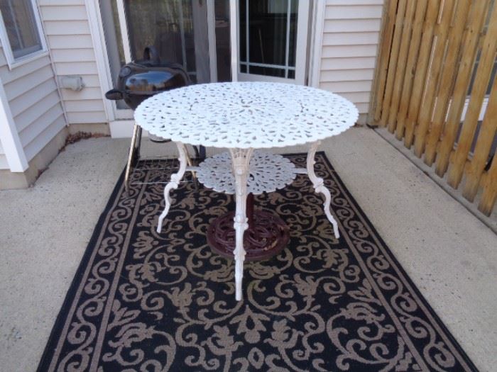 Wrought iron round outdoor table & outdoor area rug