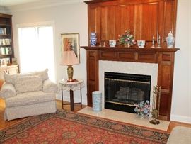 Living room - upholstered oversized armchair with matching ottoman, vintage end table, brass lamp, Asian vases, pewter candlesticks, wool area rug