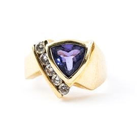 14K Yellow Gold, Tanzanite, and Diamond Ring: A 14k yellow gold, tanzanite, and diamond ring. It features a natural heat treated Tanzanite center stone and a line of diamond side stones on a gold band.