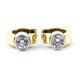 14K Yellow Gold and Diamond Earrings: A pair of 14k yellow gold and diamond earrings. They feature round brilliant cut diamonds set in a hinged C-shaped golden hoop.