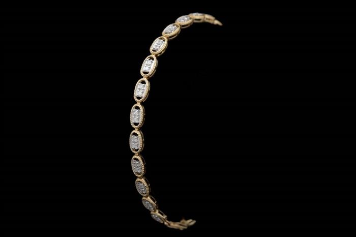 0.50 CTW Diamond and 10K Yellow Gold Bracelet: A 0.50 ctw diamond and 10K yellow gold bracelet. Each link features two diamonds set with white gold prongs inside 10K yellow gold rope lined ovals.