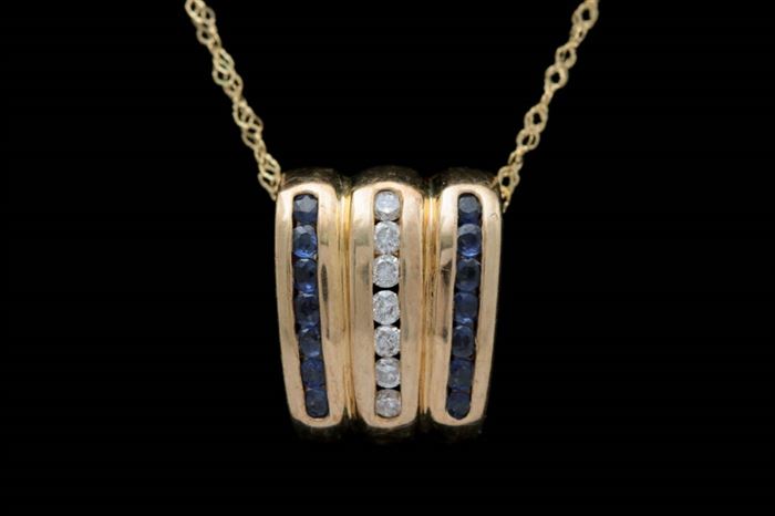 14K Gold, Blue Sapphire and Diamond Slide Pendant with Chain: A 14K gold, blue sapphire and diamond slide pendant with chain. The wedge-shaped slide measures approximately 0.45" x 0.55" and features seven channel-set diamonds flanked by two rows of channel-set blue sapphires. Included is an 18" 14K yellow gold cable chain