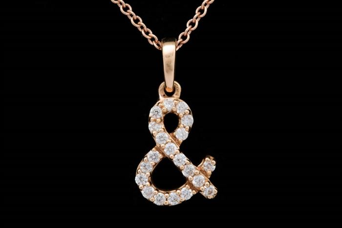 18K Rose Gold and Diamond "Ampersand" Pendant and Chain: An 18K rose gold and diamond “ampersand” pendant with chain. The pendant hangs from a 16" 18K rose gold cable chain with a lobster claw clasp.