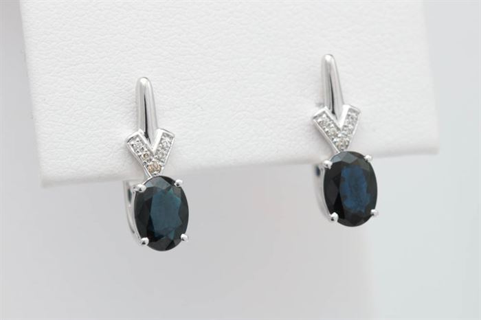 1.90 CTW Blue Sapphire, Diamond, and 14K White Gold Earrings: A pair of 1.90 ctw blue sapphire, diamond and 14K white gold earrings. The earrings feature two, oval blue sapphires accented with diamonds.