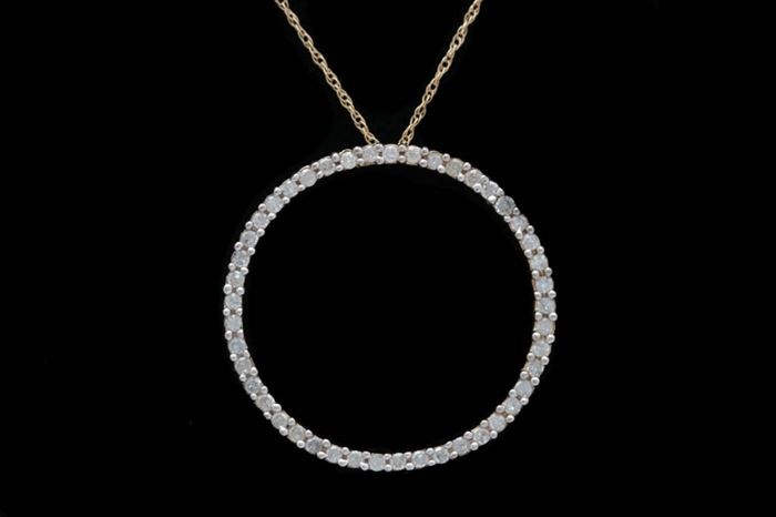 0.50 CTW Diamond and 10K Gold Circle Pendant with Chain: A 0.50 ctw diamond and 10K gold circle pendant with chain. The gold circle pendant is lined with forty-five diamonds and measures approximately 1.00" in diameter. The pendant hangs from hidden bail on an 18" 10K yellow gold cable chain.