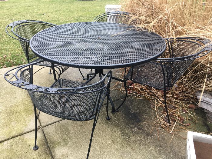 Selection of outdoor furniture and decor including a black Woodard wrought iron table with 4 chairs.