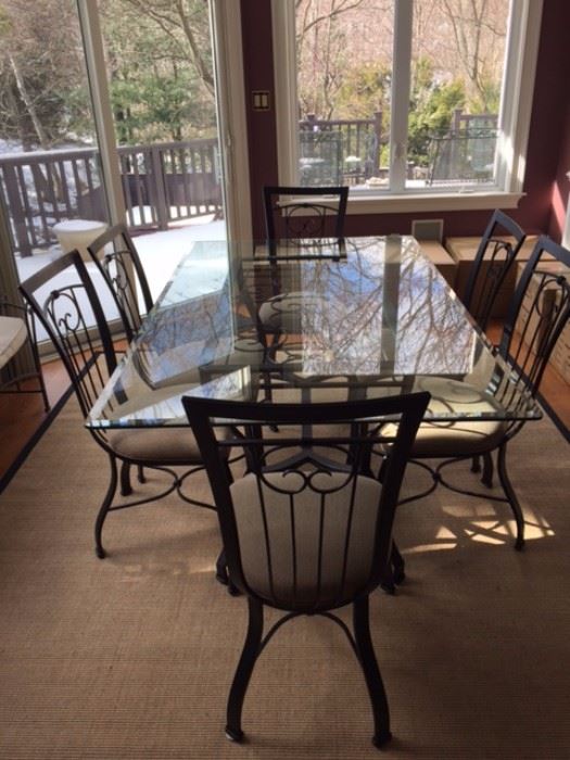 72 x 42 in Glass Table with beautiful iron-work support. Includes 6 iron, upholstered chairs.