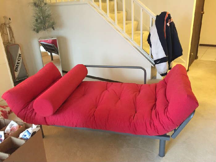 Red single futon opens to sleep and folds to couch