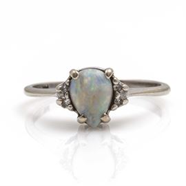 TruBrite 14K White Gold Opal and Diamond Ring: A 14K white gold opal and diamond ring by TruBrite. The opal center stone displays red, green, and blue color play and is flanked by diamond side stones.