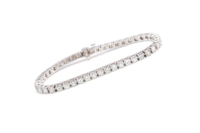 14K White Gold 7.12 CTW Diamond Bracelet: A white gold tennis bracelet set with round cut basket prong set diamonds.