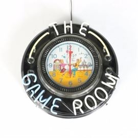 "The Game Room" Neon Clock Sign: A neon clock sign. This clock has red hands and blue numbers with a couple dancing at a diner with a jukebox. The clock features a neon sign around the border that reads “The Game Room”.