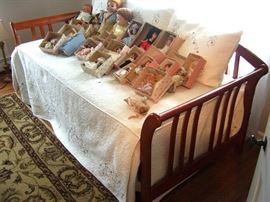 Day bed with trundle and large and small dolls.